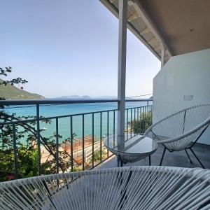 a balcony with two chairs and a view of the ocean at Ponti Bay Apartments in Vasiliki