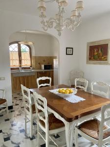 a dining room with a wooden table and white chairs at Villa Silvana in Querceta