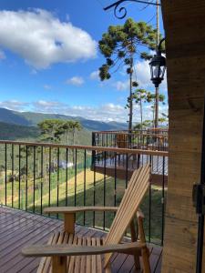 a wooden deck with a bench and a view of the mountains at Pousada Villa Barril in Monte Verde