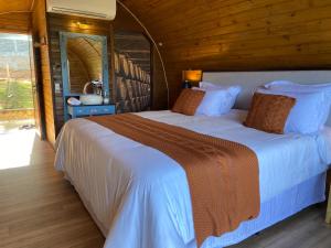 モンテ・ヴェルデにあるPousada Villa Barrilのベッドルーム(白いシーツを使用した大型ベッド1台付)
