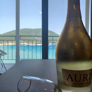 a bottle of beer sitting on a table with a glass at Ponti Bay Apartments in Vasiliki
