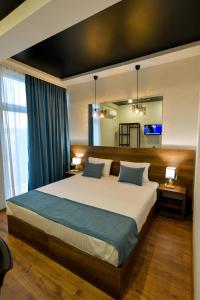 a bedroom with a large bed and a mirror at Hill Hotel in Kutaisi