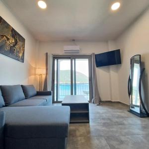 a living room with a couch and a large window at Ponti Bay Apartments in Vasiliki