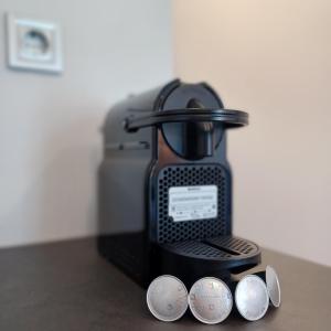 a coffee maker with four coins on a counter at Ponti Bay Apartments in Vasiliki