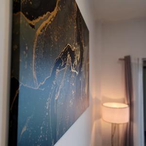 a painting hanging on a wall next to a lamp at Ponti Bay Apartments in Vasiliki