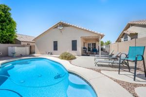 a swimming pool with chairs and a house at Topeka Tops in Phoenix