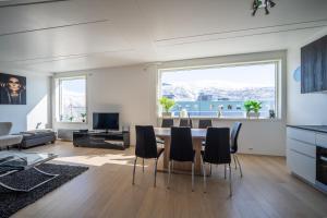 a living room with a dining room table and chairs at Arctic Homes - Premium Tromsø Residence in Tromsø