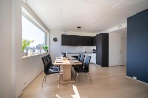 kuchnia i jadalnia ze stołem i krzesłami w obiekcie Arctic Homes - Premium Tromsø Residence w mieście Tromsø