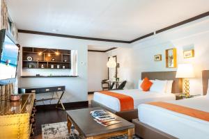 Cette chambre comprend 2 lits et une table. dans l'établissement Lincoln Arms Suites, à Miami Beach