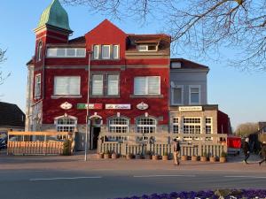 a large red building with a person walking in front of it at Workers Sleep in Wilhelmshaven