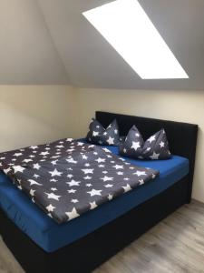 a bed with a blue bedsheet with stars on it at Workers Sleep in Wilhelmshaven