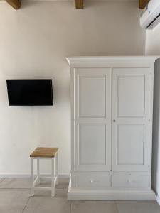 a white wall with a white cabinet and a table at Koralline accommodation in Tropea