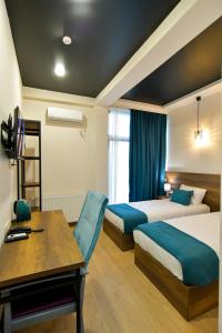 um quarto de hotel com duas camas e uma secretária em Hill Hotel em Kutaisi