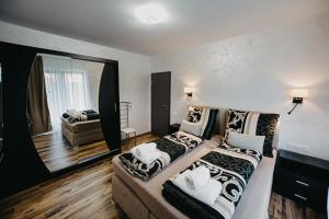 a bedroom with two beds and a living room at Ap.Casa la Neamtu in Sibiu
