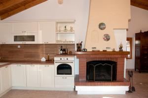 a kitchen with white cabinets and a fireplace at Pyrgos Fassea Kardamyli in Kardamyli
