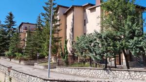 a building with trees in front of it at RESIDENCE LA REGINA DELLA NEVE in Roccaraso