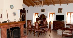 a living room with a fireplace and a table and chairs at Pyrgos Fassea Kardamyli in Kardamyli
