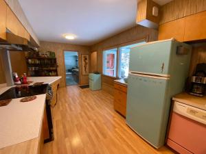 een keuken met een witte koelkast en houten vloeren bij All the Waters Retro Home on Lake Michigan- Your Own PRIVATE BEACH in Benton Harbor