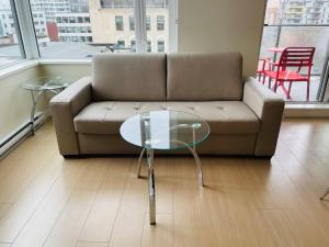 a living room with a couch and a glass table at Lovely downtown 2 bedroom condo with free parking in Victoria