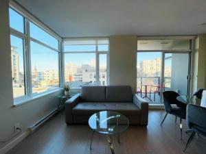 a living room with a couch and a glass table at Lovely downtown 2 bedroom condo with free parking in Victoria