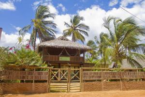 a small hut with palm trees in the background at KazaBrasil in Icaraí