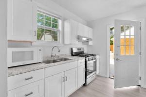 a white kitchen with a sink and a stove at Near Fort Walton Beach, peaceful 5 bedrooms house in Fort Walton Beach