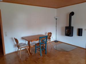 a dining room with a wooden table and chairs at ruhig gelegene Allgäuer Ferienwohnung in Scheidegg