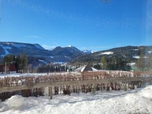 a fence in the snow with mountains in the background at Stadtzentrum Mariazell in Mariazell