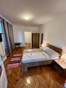 una camera da letto con un letto grande e un pavimento in legno di Apartmani Grand Market a Sarajevo