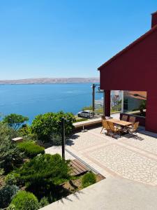 a patio with a table and chairs and the ocean at Apartments Angela in Cesarica