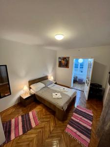 una camera da letto con un letto e una TV su un pavimento in legno di Apartmani Grand Market a Sarajevo