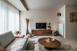 uma sala de estar com um sofá e uma mesa de centro em - Carijoca - Gemoderniseerd, lichtrijk & zijdelings zeezicht app em Koksijde