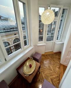 un soggiorno con ampie finestre e un tavolo di Apartmani Grand Market a Sarajevo