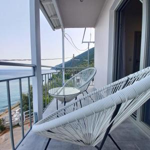 a white bench on a balcony with a view of the ocean at Ponti Bay Apartments in Vasiliki