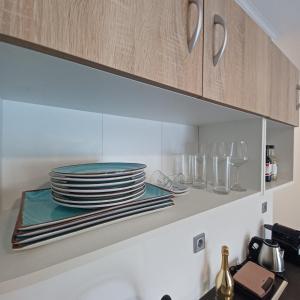 a kitchen with plates and glasses on a shelf at Ponti Bay Apartments in Vasiliki