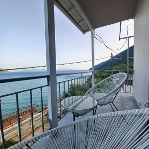 a balcony with two chairs and a view of the ocean at Ponti Bay Apartments in Vasiliki