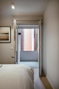 a bedroom with a bed and a window at - Carijoca - Gemoderniseerd, lichtrijk & zijdelings zeezicht app in Koksijde