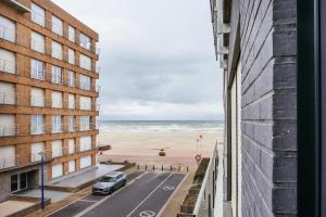 uma vista para a praia a partir da varanda de um edifício em - Carijoca - Gemoderniseerd, lichtrijk & zijdelings zeezicht app em Koksijde