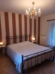 a bedroom with a bed and a chandelier at CASOLARE TROMBACCO in Vergemoli
