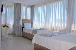 ein Hotelzimmer mit zwei Betten und einem Fenster in der Unterkunft YASMİN Hotel in Istanbul + 11 Fotos