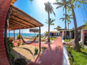 a resort with a hammock and the beach at Hotel Punta Ballenas in Máncora