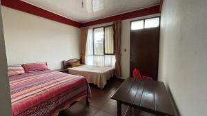 a bedroom with a bed and a table and a window at Hotel Puerto Selva in Villa Tunari