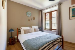 um quarto com uma cama e uma janela em LE RHENANUS Martin Bucer - grand appartement au calme - centre ville - parking gratuit em Sélestat