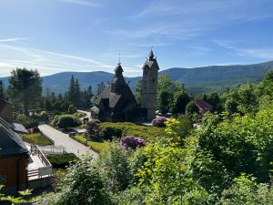 une église avec une tour au milieu d'un village dans l'établissement Royal Green - Apartamenty Deptak, à Karpacz