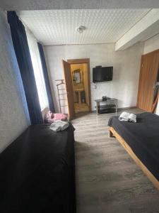 a hotel room with two beds and a television at Cottage - Location Lanchvali in Mestia