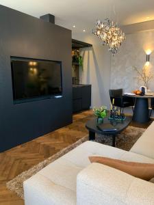 a living room with a white couch and a table at Brabant Suites in Nistelrode