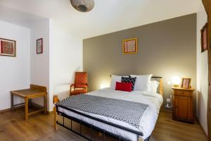 a bedroom with a large bed and a chair at LE RHENANUS Ludwig Dringenberg - appartement au calme - centre ville - parking gratuit in Sélestat