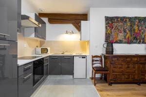a kitchen with stainless steel appliances and a painting on the wall at LE RHENANUS Ludwig Dringenberg - appartement au calme - centre ville - parking gratuit in Sélestat
