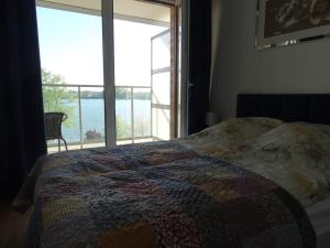 a bedroom with a bed and a large window at ApartamentPromenadaEłk in Ełk