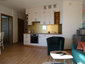 uma cozinha e sala de estar com um sofá e uma mesa em ApartamentPromenadaEłk em Ełk